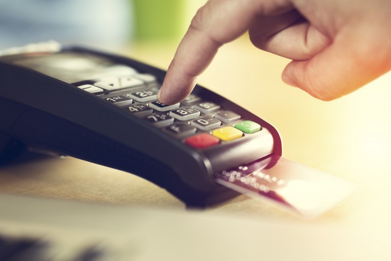 Hand with credit card swipe through terminal for sale