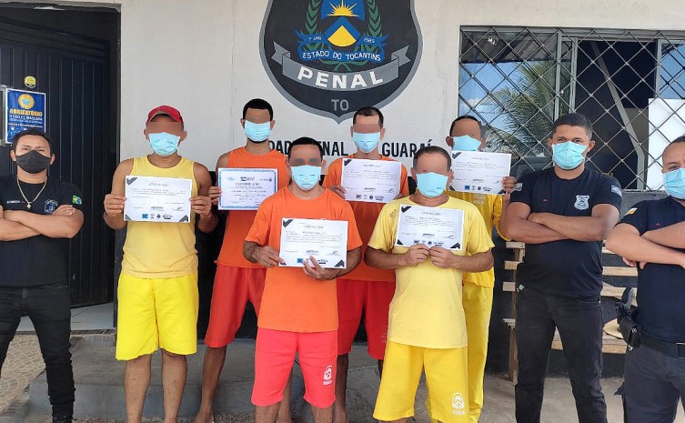 Custodiados da Unidade Penal de Guaraí posam com seus certificados ao lado dos policiais penais - Foto: Seciju/Governo do Tocantins